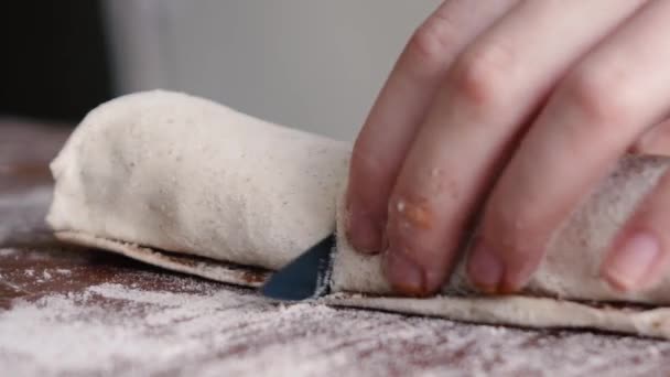 The woman cuts the dough with the cinnamon into parts — Stock Video