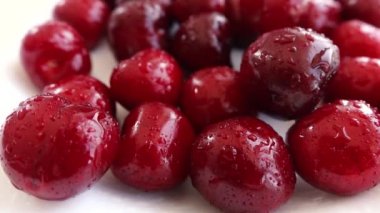 Adam tabaktan kirazları tek tek alıyor.