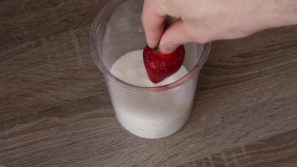 Hand taucht Erdbeeren in Zucker — Stockvideo