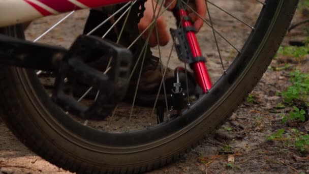 Un hombre bombea una rueda de bicicleta de cerca — Vídeos de Stock