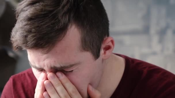En allergisk man nyser när han sitter i huset — Stockvideo