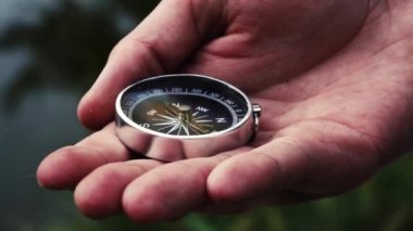 Adamın elinde bir pusula var.