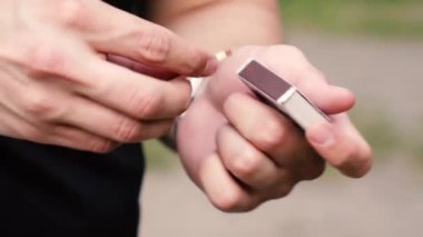 Bir adam sokakta kibrit yakar.