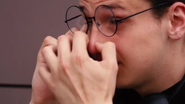 En man som pratar i telefon och justerar sina glasögon — Stockvideo