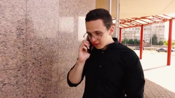 Homme d'affaires joyeux marche dans la rue et parle au téléphone — Video