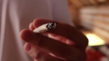 Bir adam elinde sigara tutuyor. Yakından.
