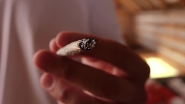 Ένας άντρας κρατάει ένα τσιγάρο στο χέρι του από κοντά. — Αρχείο Βίντεο