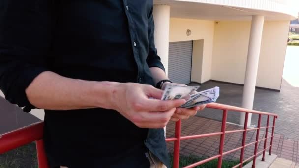 Homem conta dinheiro em pé na rua perto das escadas — Vídeo de Stock