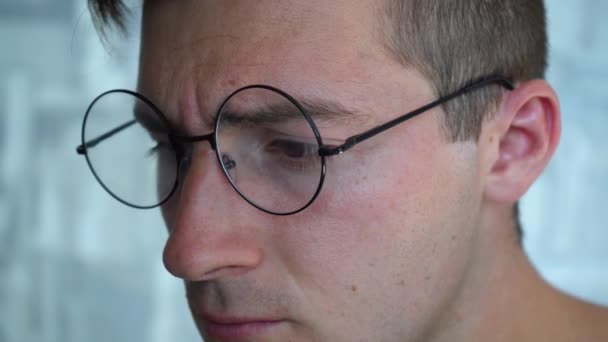 Egy férfi hacker kerek szemüveggel keményen dolgozik egy laptopon — Stock videók