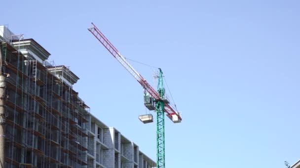 Una grúa de construcción transfiere estructuras al edificio — Vídeo de stock