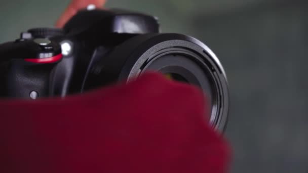 카메라 렌즈에 있는 먼지를 티셔츠로 닦는 남자 — 비디오