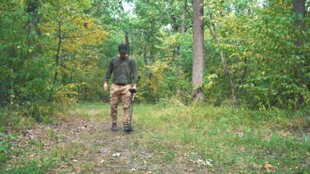 Uomo cammina attraverso il bosco con un metal detector — Video Stock