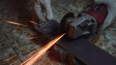 Adam kıvılcımlar saçan testere ile metali kesiyor..