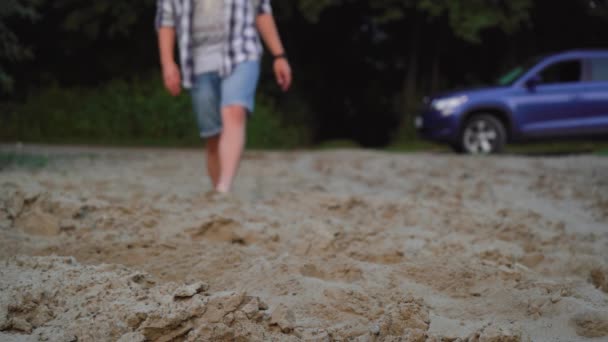 Άντρας περπατά στην παραλία με γυμνά πόδια — Αρχείο Βίντεο
