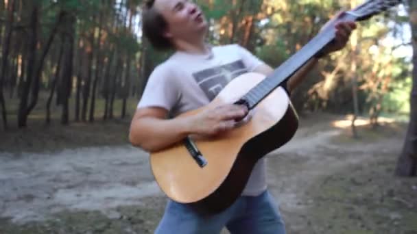 Uomo che suona la chitarra selvaggiamente e si contorce — Video Stock