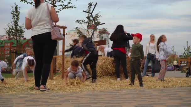 Много детей играют с стогом сена в парке. Россия Старый Оскол 5 2020 — стоковое видео