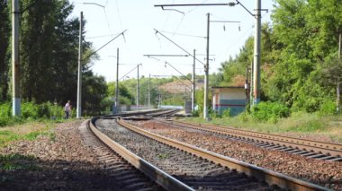 Tren yokken insanlar demiryolunu geçiyor.