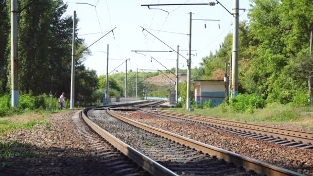 Az emberek átkelnek a vasúton, amíg nincsenek vonatok. — Stock videók