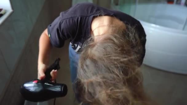 Girl dries her hair with a hair dryer in the bathroom — Stock Video