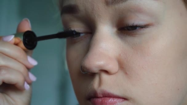 Gadis melukis bulu matanya duduk di depan cermin. — Stok Video