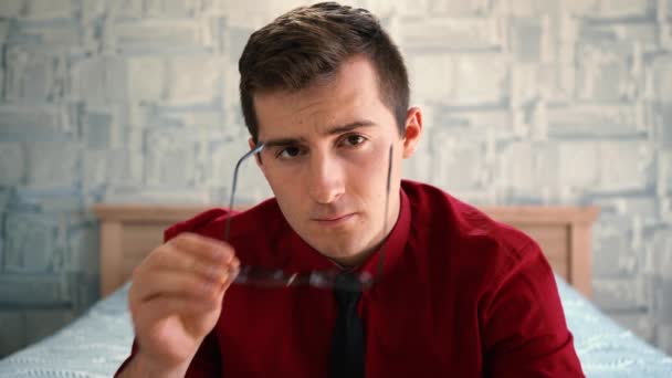 Hombre se pone gafas y mira a la cámara — Vídeos de Stock