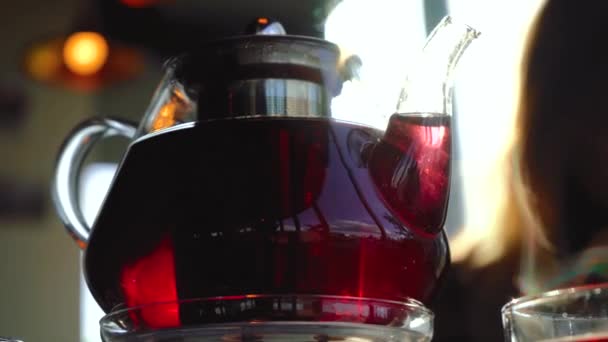 Rode thee wordt gegoten in een glazen theepot — Stockvideo