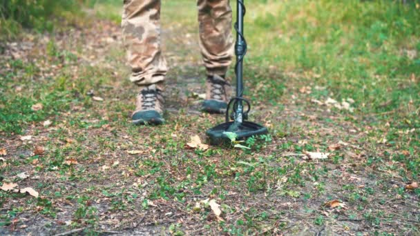 Hombre camina con un detector de metales a través del bosque y busca metal — Vídeo de stock