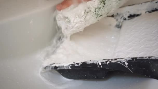 Constructeur lave le rouleau avec un seau de peinture blanche — Video