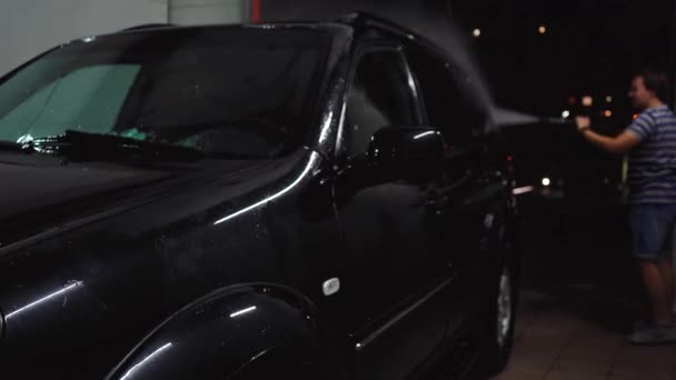 Férfi lemossa az autót egy autómosóban. — Stock videók