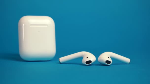 AirPods inalámbricos de Apple sobre fondo azul. Moscú Rusia 20 septiembre 2020 — Vídeos de Stock