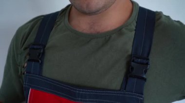 Erkek çalışan işçi tulumunu çıkartıyor.