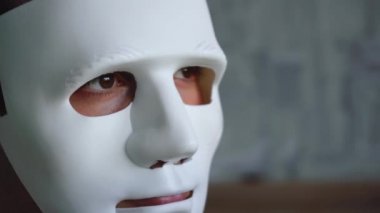 Adam isimsiz bir maske takıyor.