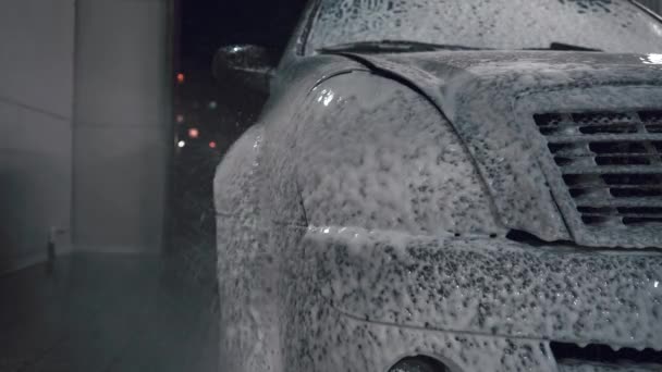 Mannen vattnar bilen med skum — Stockvideo