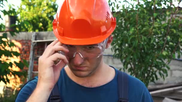 Constructor cansado se quita las gafas y el casco — Vídeo de stock