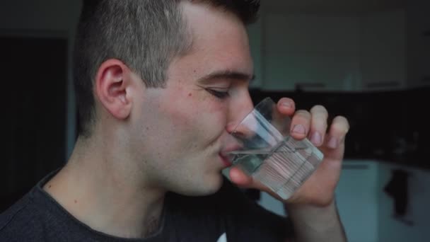 El hombre bebe un vaso de agua por la mañana temprano. — Vídeos de Stock