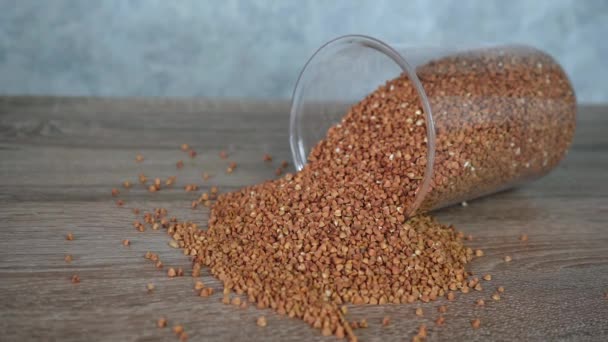 Fallen glass jar with crumbled buckwheat — Stock Video