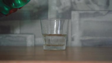 Adam bardağa su dolduruyor şişeden..