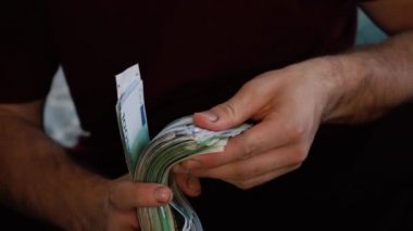 Adamın elinde büyük bir para yığını var.