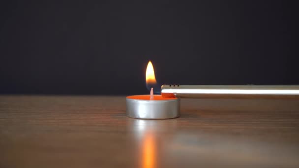Hombre enciende una vela naranja con un encendedor — Vídeos de Stock