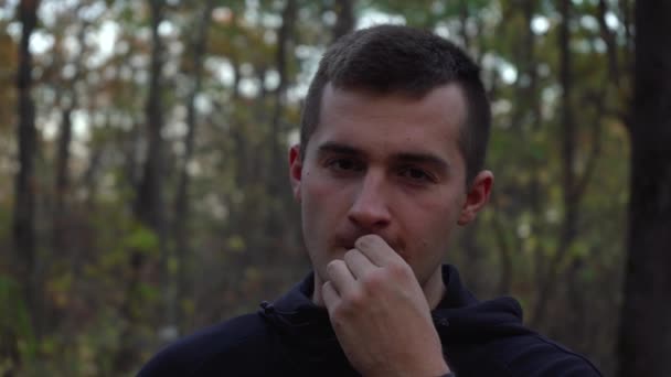 Een man in het bos eet zonnebloempitten — Stockvideo