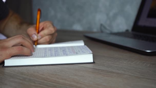 Homem faz anotações em um caderno preto — Vídeo de Stock