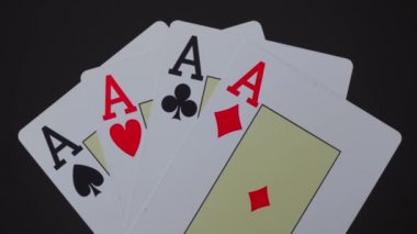 Siyah arkaplanda dört as yaklaşıyor.