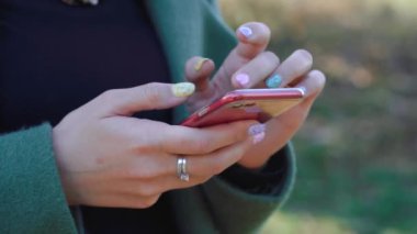 Kız sokakta telefon kullanıyor.