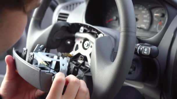 Чоловік ремонтує кермо автомобіля — стокове відео