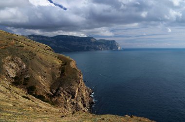 Geleneksel Ukrayna yaz manzara Crimea ve mavi deniz ve gökyüzü bulutlu. Dağ yamaçları kuru ot ile kaplıdır