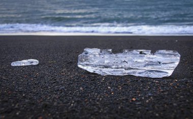 İki şeffaf buz blokları Black Beach İzlanda'nın Atlantik Okyanusu kıyısında yalan