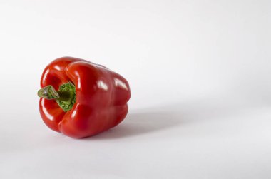 Beyaz bir arka plan üzerinde sulu kırmızı Bulgar biber yeşil bir kuyruklu yalan