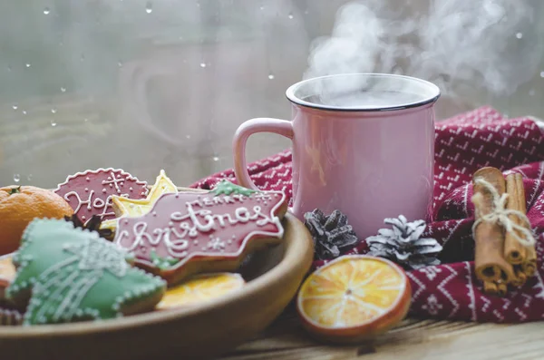 熱いお茶のカップ スタンド木製の横に木製のテーブルでプレートには水滴とウィンドウの背景にオレンジのスライスから作られたジンジャーブレッド クッキー — ストック写真
