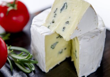 Ahşap tahta üzerinde çeşitli peynirler. Camembert, mavi küf ile peynir, domates ve biberiye mozzarella