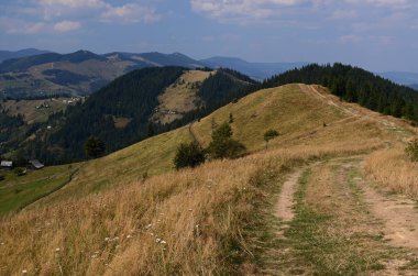 Toprak yol yüksek vadi köyde gideceği mavi gökyüzü bulutlu karşı dağlarda
